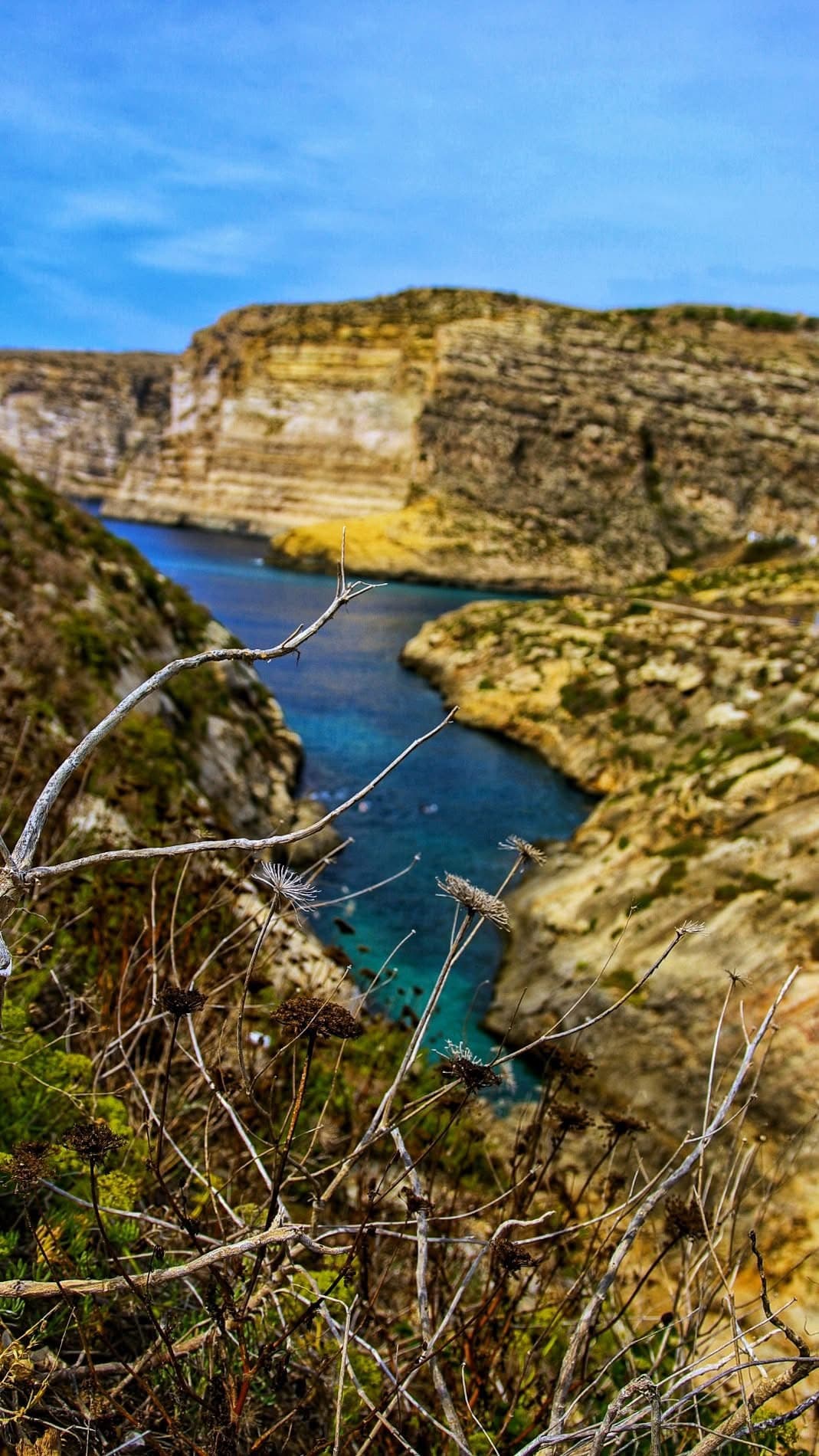 Hidden inlet between Gozo cliffs — crystal clear water