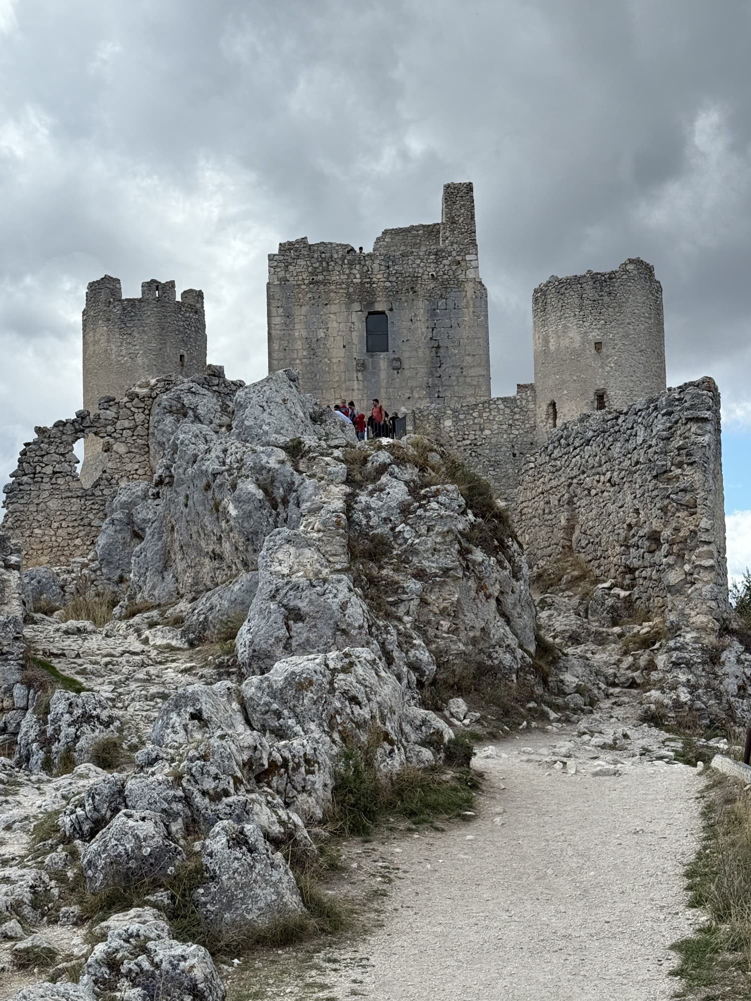 Rocca Calascio fortress rising from its hilltop against dramatic storm clouds in Abruzzo